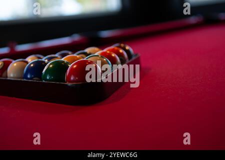 Blick auf die Poolbälle in einem Dreiecksregal auf einem roten Filztisch. Stockfoto