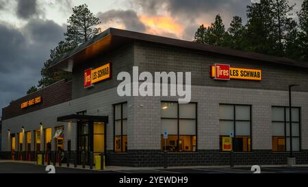 CLE Elum, WA, USA - 28. Oktober 2024; Abendlicht im Reifengeschäft Les Schwab mit beleuchteten Schildern Stockfoto