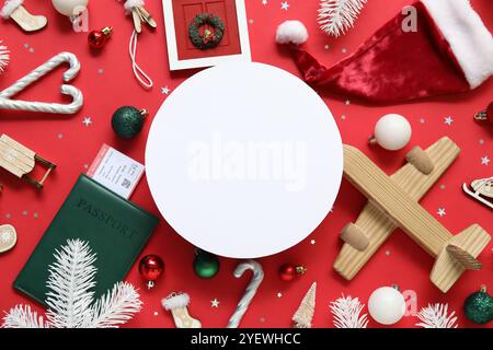 Rahmen aus Spielzeug, Holzflugzeug und Reisepass auf rotem Hintergrund. Weihnachtsferienkonzept Stockfoto