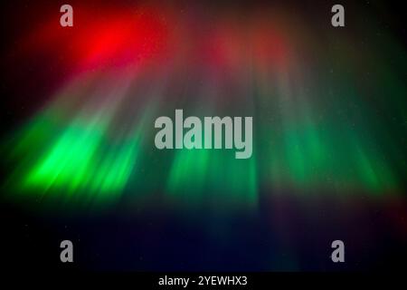 Leuchtende rote und grüne Auroras (Nordlichter) bemalen den Nachthimmel und schaffen eine faszinierende und surreale Atmosphäre über der Grand Traverse Bay, Michigan, Stockfoto