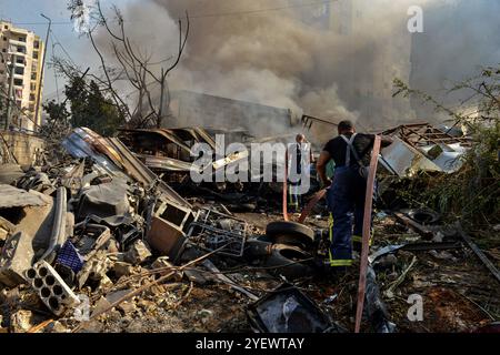 Beirut, Beirut, Libanon. November 2024. Feuerwehrleute drängen sich durch Schutt und zerstörte Autos, um Feuer in zerstörten Gebäuden zu gießen, die von israelischen Luftangriffen auf den südlichen Vorort Beiruts, einem Brutgebiet der pro-iranischen Hisbollah, angegriffen wurden. (Kreditbild: © Marwan Naamani/ZUMA Press Wire) NUR REDAKTIONELLE VERWENDUNG! Nicht für kommerzielle ZWECKE! Stockfoto