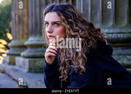 Das schöne weibliche Model Ava Nicholson entspannt sich auf der Treppe des neoklassizistischen Dundee Camperdown House, geschützt vor der Herbstsonne, Schottland Stockfoto