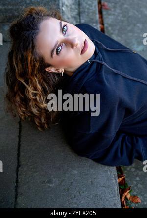 Das schöne weibliche Model Ava Nicholson entspannt sich auf der Treppe des neoklassizistischen Dundee Camperdown House, geschützt vor der Herbstsonne, Schottland Stockfoto