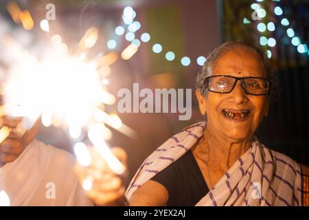 Eine ältere Frau aus Pramod Talukdar Memorial Old Age Home Burn Wunderknacker Crackersas feiert Diwali in Guwahati, Indien am 1. November 2024. Diwali, auch bekannt als Festival der Lichter, ist eines der am weitesten gefeierten Hindufeste, das den Sieg des Lichts über die Dunkelheit und des Guten über das Böse symbolisiert. Quelle: David Talukdar/Alamy Live News Stockfoto