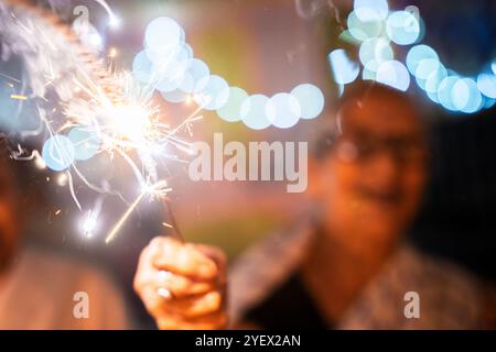 Eine ältere Frau aus Pramod Talukdar Memorial Old Age Home Burn Wunderknacker Crackersas feiert Diwali in Guwahati, Indien am 1. November 2024. Diwali, auch bekannt als Festival der Lichter, ist eines der am weitesten gefeierten Hindufeste, das den Sieg des Lichts über die Dunkelheit und des Guten über das Böse symbolisiert. Quelle: David Talukdar/Alamy Live News Stockfoto