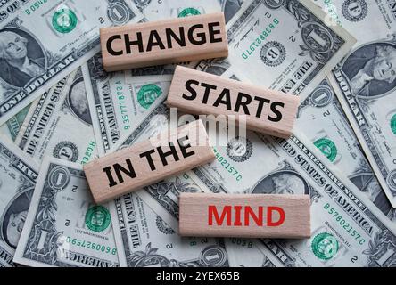 Veränderung beginnt im Gedankensymbol. Konzeptworte Veränderung beginnt im Geist auf Holzblöcken. Wunderschöner Dollar-Hintergrund. Geschäft und Wandel beginnen in Stockfoto