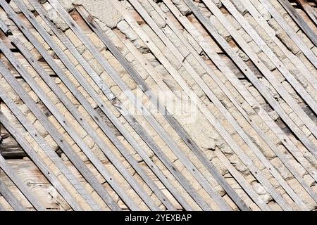 Die Textur der Wand eines Hauses mit Holz und Boden mit Sand Stockfoto