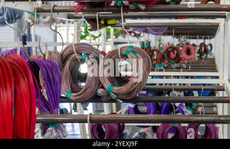 Regal und Rack mit Drähten und Kabeln in einem Hersteller von Kabelbäumen für Autos Stockfoto