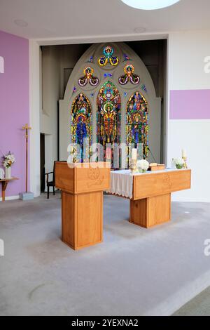 Altar und Buntglasfenster der Heiligen Familie in der Kirche St. Mary of the Rosenkranz, eine Kreation von Harry Clarke; Cong, County Mayo, Irland. Stockfoto