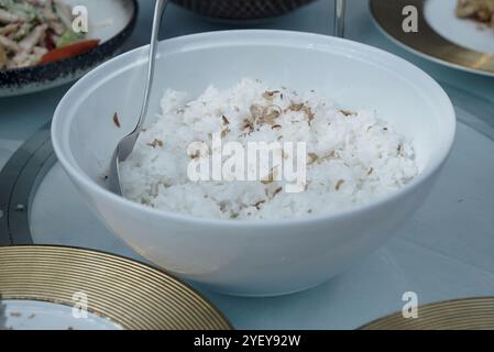 Weißer Reis mit gebratenen Zwiebeln in einer großen weißen Schüssel servieren Stockfoto