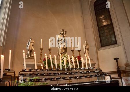 Eine Reihe brennender Kerzen, die vor der Marienstatue in der Kathedrale von St. Peter dem Apostel (Cattedrale di San Pietro Apostolo) platziert werden Stockfoto