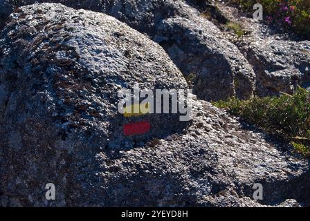 Felsen mit Wegmarkierung. Markierung, die den Wanderern den Weg anzeigt, den sie innerhalb einer Wanderroute folgen. Stockfoto