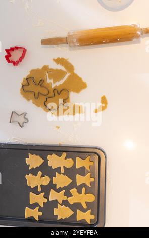 weihnachtskekse backen mit festlichen Schneidemaschinen auf der Küchentheke, zu Hause Stockfoto
