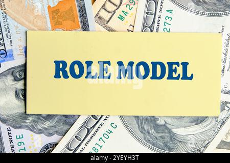 Der Begriff Wirtschaft und Bildung. Konzept Wort, Satz, Text VORBILD es ist auf gelbem Papier vor dem Hintergrund von Dollarscheine geschrieben Stockfoto