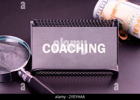 Geschäftskonzept. Der Satz, Text, Wortwahl COACHING ist auf der Visitenkarte in weißen Buchstaben auf dunklem Hintergrund geschrieben. Stockfoto
