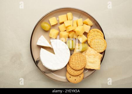 Käseplatte mit verschiedenen Käse und Crackern auf Platte auf hellem Hintergrund. Stockfoto