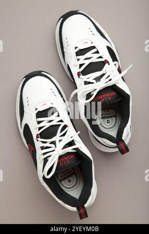 Mykolaiv, UKRAINE - Juli 2024. NIKE AIR MONARCH. Damensportschuhe auf grauem Hintergrund. Stockfoto
