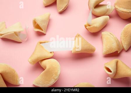 Leckere Glückskekse und Papier mit Vorhersage auf rosa Hintergrund. Stockfoto