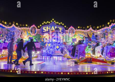 Ein beleuchtetes Karussell im Vergnügungspark bei Nacht, Menschen und Lichter, Cannstatter Wasen, Volksfest, Bad Cannstatt, Stuttgart, Baden-W Stockfoto