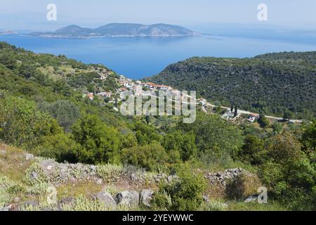 Küstenlandschaft mit einem Dorf umgeben von grünen Hügeln und dem blauen Meer im Hintergrund, Palea Loutra, Methana, Halbinsel in der Argolis auf dem Stockfoto