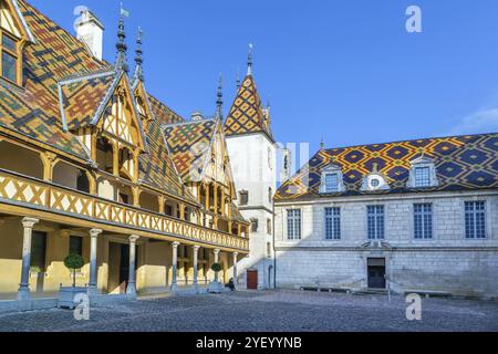 Hospices de Beaune oder Hotel-Dieu de Beaune ist eine ehemalige karitative Almshouse in Beaune, Frankreich. Innenhof, Innenfassade mit polychromem Dach Stockfoto