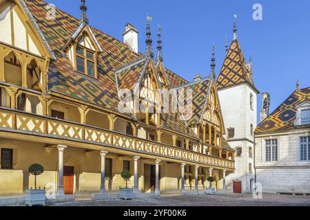 Hospices de Beaune oder Hotel-Dieu de Beaune ist eine ehemalige karitative Almshouse in Beaune, Frankreich. Innenhof, Innenfassade mit polychromem Dach Stockfoto