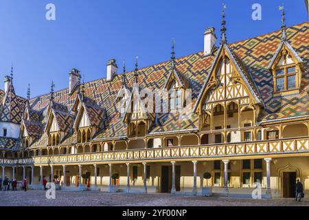 Hospices de Beaune oder Hotel-Dieu de Beaune ist eine ehemalige karitative Almshouse in Beaune, Frankreich. Innenhof, Innenfassade mit polychromem Dach Stockfoto