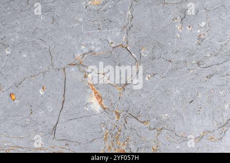 Raue graue Steinoberfläche mit natürlichen Rissen und Grautönen. Ideal als Hintergrund für Websites Stockfoto
