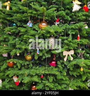 Weihnachtsbaum grüner festlicher Hintergrund. Weihnachtsbaum mit Girlandenbeleuchtung, vielen Spielzeugen, Engeln, Bällen Stockfoto