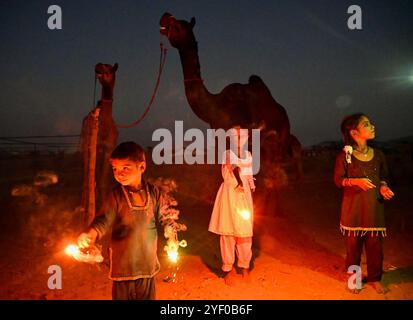 Ajmer, Indien. November 2024. Kamelhirten zünden Feuerwerkskörper an, während sie das Diwali-Festival in Puschkar feiern. Diwali, auch bekannt als Festival der Lichter, ist eines der am weitesten gefeierten Hindufeste, das den Sieg des Lichts über die Dunkelheit und des Guten über das Böse symbolisiert. (Foto: Shaukat Ahmed/Pacific Press) Credit: Pacific Press Media Production Corp./Alamy Live News Stockfoto