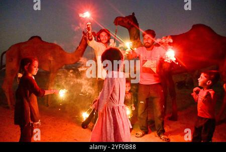 Ajmer, Indien. November 2024. Kamelhirten zünden Feuerwerkskörper an, während sie das Diwali-Festival in Puschkar feiern. Diwali, auch bekannt als Festival der Lichter, ist eines der am weitesten gefeierten Hindufeste, das den Sieg des Lichts über die Dunkelheit und des Guten über das Böse symbolisiert. (Foto: Shaukat Ahmed/Pacific Press) Credit: Pacific Press Media Production Corp./Alamy Live News Stockfoto