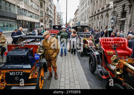 London, Großbritannien. November 2024. Der Besitzer eines 1897er Daimler überprüft das Auto, während Besucher an den wunderschön aufgereihten Veteranenautos spazieren gehen. Das St James's Motoring Spectacle wird als Londons größte, frei zugängliche Autoshow gepriesen, die das Beste aus der Vergangenheit, Gegenwart und Zukunft feiert. Viele der Oldtimer-Modelle nehmen auch an der morgigen Rennbahn Teil. Quelle: Imageplotter/Alamy Live News Stockfoto