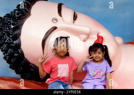 Phuoc Hue buddhistische Pagode. Riesige goldene liegender Buddha-Statue mit Kindern. Vietnam. Stockfoto