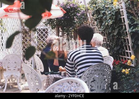 Ein junges Paar, das mittags in einem Restaurant im Garten sitzt, Porters Weinbar, Hastings, East Sussex, England. Stockfoto