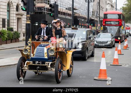 London, Großbritannien. 2. November 2024. Ein Paar in historischen Kostümen, das mit seinem Veteranenfahrzeug zur Pall Mall fährt, um das Motorspektakel von St. James zu erleben. Veteranenfahrzeuge werden am nächsten Morgen im RM Sotheby’s London zum Brighton Veteran Car Run gefahren, der zum 128. Mal mit Teilnehmern aus aller Welt stattfindet. Die Veranstaltung wird vom Royal Automobile Club außerhalb des Hauptsitzes ausgerichtet. Quelle: Stephen Chung / Alamy Live News Stockfoto