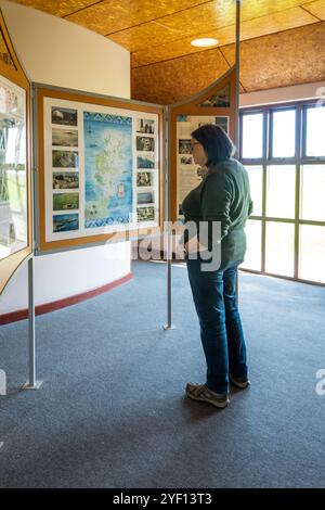 Frau liest eine Ausstellung im Orkneyinga Saga Centre, Orphir, Festland Orkney. Stockfoto