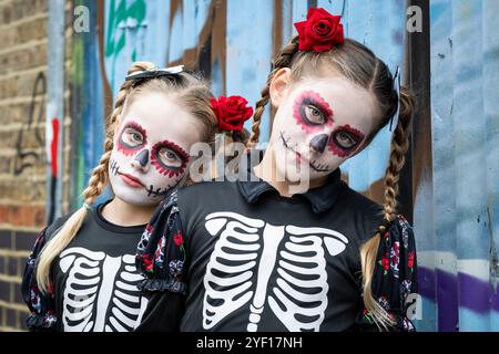 London, Großbritannien. 2. November 2024. (L) Amelia und Gracie, beide 10 Jahre alt, feiern in Kostümen und Schminke den mexikanischen Tag der Toten an der Columbia Road in East London. Der mexikanische Tag der Toten ist, trotz seines Namens, eine freudige Feier zu Ehren des Vergehens der Angehörigen, an der die Geister der Ahnen zurückkehren und mit dem Christentum der Heiligsten in der Eva zusammenfallen. (Erlaubnis der Eltern erhalten) Credit: Stephen Chung / Alamy Live News Stockfoto