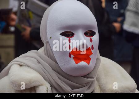 London, Großbritannien. November 2024. Während des marsches in Zentral-London steht ein palästinensischer Demonstrant mit einer Maske vor der Downing Street, der in Solidarität mit Palästina und dem Libanon ein Ende der israelischen Angriffe fordert. Quelle: SOPA Images Limited/Alamy Live News Stockfoto