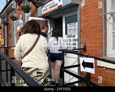 Church Village, Pontypridd, Wales, Vereinigtes Königreich - 4. Juli 2024: Menschen, die in einer Wahlstation anstehen, um ihre Stimme abzugeben. Stockfoto