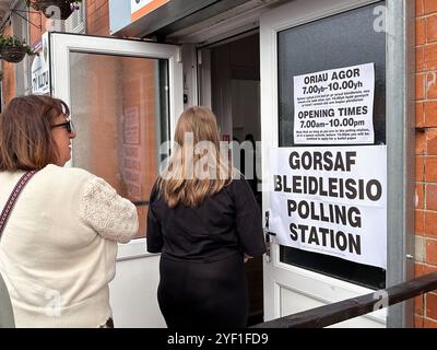 Church Village, Pontypridd, Wales, Vereinigtes Königreich - 4. Juli 2024: Menschen, die in einer Wahlstation anstehen, um ihre Stimme abzugeben. Stockfoto