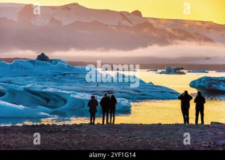 Eis Lagune. Silhouette von Touristen unter Foto, Sonnenuntergang Eis Lagune. South Island, Jokulsarlon Eis Wasserfall. Große touristische Attraktion. Stockfoto