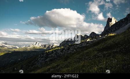 Ein malerischer, grasbewachsener Hügel, der mit lebhaftem Grün geschmückt ist, erhebt sich sanft mit einem majestätischen Berg, der eindrucksvoll im Hintergrund thront Stockfoto