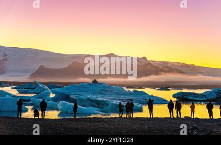 Eis Lagune. Silhouette von Touristen unter Foto, Sonnenuntergang Eis Lagune. South Island, Jokulsarlon Eis Wasserfall. Große touristische Attraktion. Stockfoto