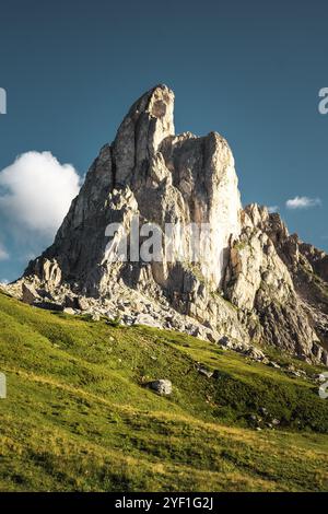 Ein massiver felsiger Berg erhebt sich majestätisch über einem üppigen, grasbewachsenen Hügel und schafft eine atemberaubende natürliche Landschaft in der Ferne Stockfoto