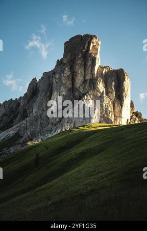 Ein malerischer, grasbewachsener Hügel, der mit lebhaftem Grün geschmückt ist, erhebt sich sanft mit einem majestätischen Berg, der eindrucksvoll im Hintergrund thront Stockfoto