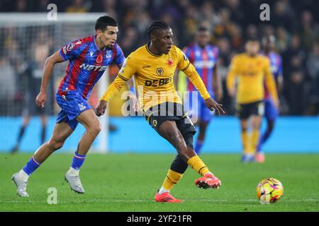 Jean-Ricner Bellegarde von Wolverhampton Wanderers lässt den Ball passieren, während Daniel Muñoz von Crystal Palace während des Premier League Spiels Wolverhampton Wanderers gegen Crystal Palace in Molineux, Wolverhampton, Großbritannien, 2. November 2024 unter Druck gesetzt wird (Foto: Gareth Evans/News Images) Stockfoto