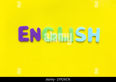 ENGLISCHES Wort mit farbigen Buchstaben auf gelbem Hintergrund mit Kopierraum. Konzept der Englischkurse. Stockfoto