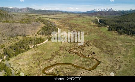 Blick aus der Vogelperspektive auf das ruhige Tal mit gewundenen Fluss und Bergen Stockfoto