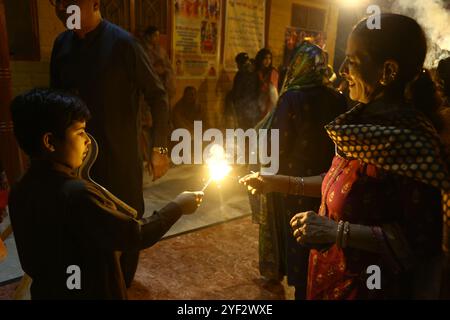 Hyderabad, Sindh, Pakistan. November 2024. Hindus Familie zündet während der Feier des Diwali Festivals in einem lokalen Tempel in Hyderabad einen Feuerwerkskörper an (Foto: © Jan Ali Laghari/Pacific Press via ZUMA Press Wire) NUR REDAKTIONELLE VERWENDUNG! Nicht für kommerzielle ZWECKE! Stockfoto