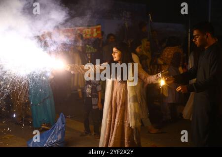 Hyderabad, Sindh, Pakistan. November 2024. Hindu-Mädchen zünden während der Feier des Diwali Festivals in einem lokalen Tempel in Hyderabad einen Feuerwerkskörper an (Foto: © Jan Ali Laghari/Pacific Press via ZUMA Press Wire) NUR REDAKTIONELLE VERWENDUNG! Nicht für kommerzielle ZWECKE! Stockfoto